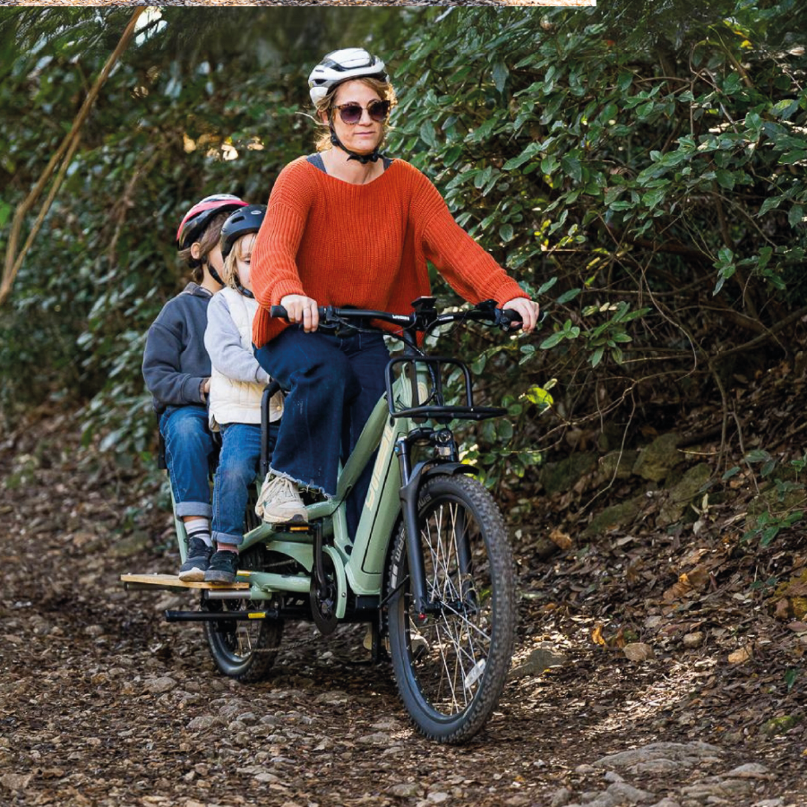 Eine Frau transportiert ihre Kinder mit Yuba Spicy curry durch den Wald