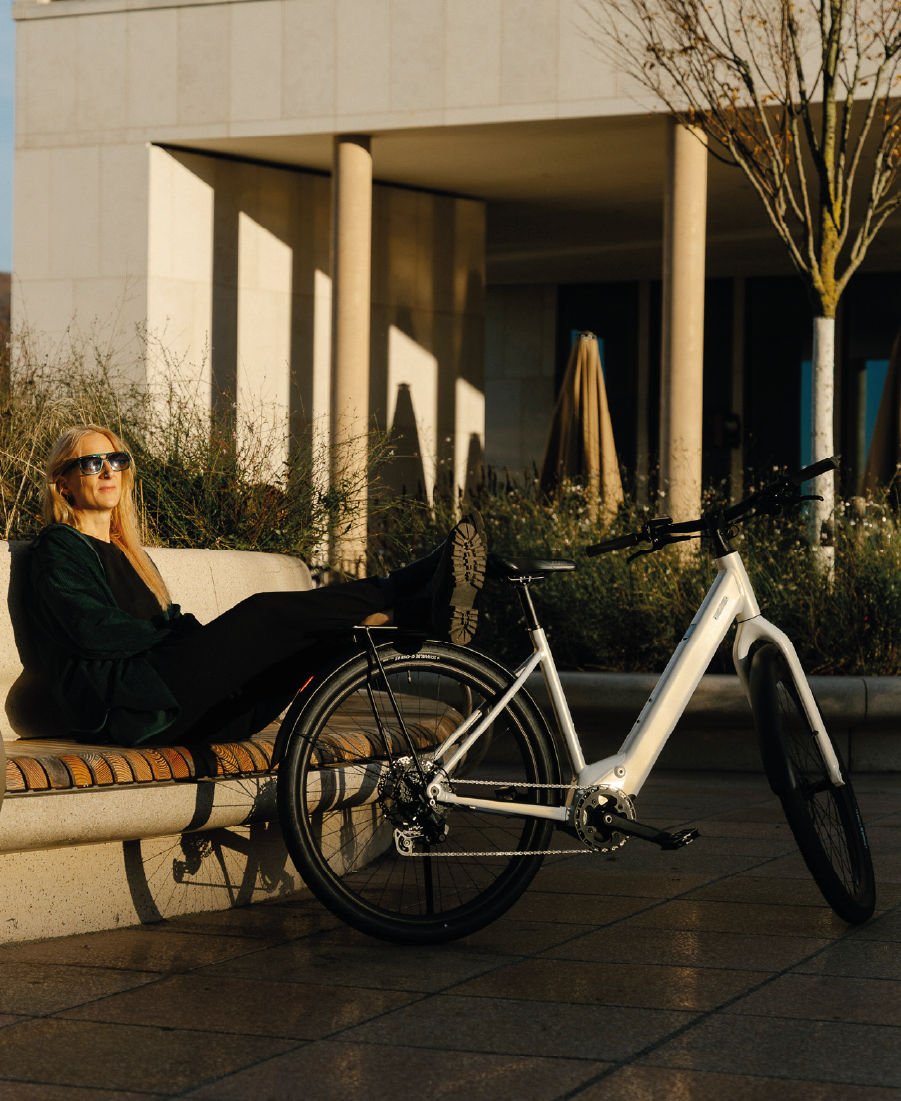 Frau entspannt auf einer Bank mit Coboc Sky Step in weiß neben sich