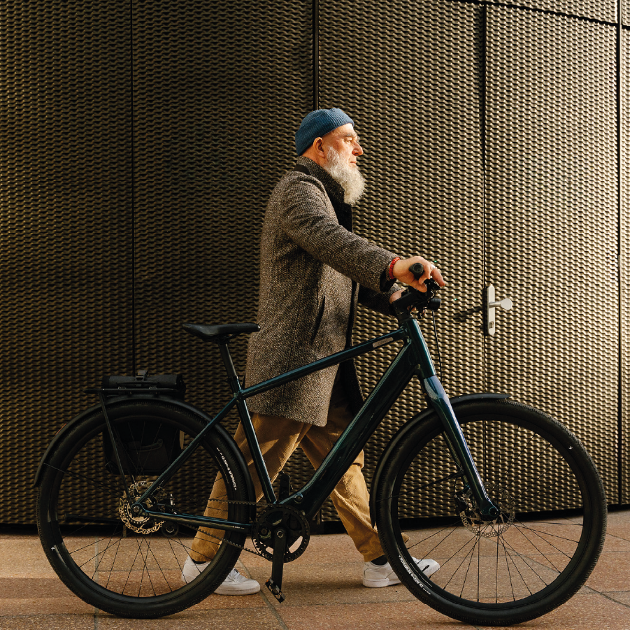 Man schiebt das Coboc Sky in ocean metallic blau durch die Stadt