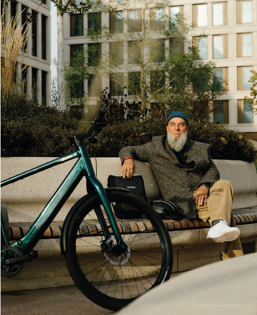 Man sitzt auf einer Bank mit Coboc Sky ocean metallic blau neben sich im Park