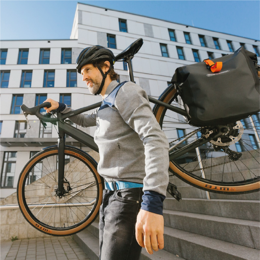 Ein Mann trägt sein Coboc Torino in Farbe giro grey, atlas black die Treppen runter